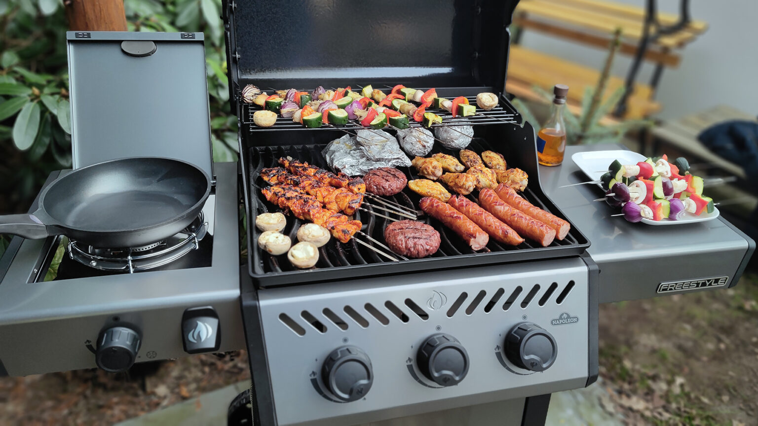 Jak włączyć grill gazowy? Wiemy, jak bezpiecznie go odpalić test czterech grilli gazowych, grille gazowe, Napoleon, ruszt grilla gazowego z jedzeniem, grillowanie; palnik boczny; kuchenka gazowa, boczna półka robocza