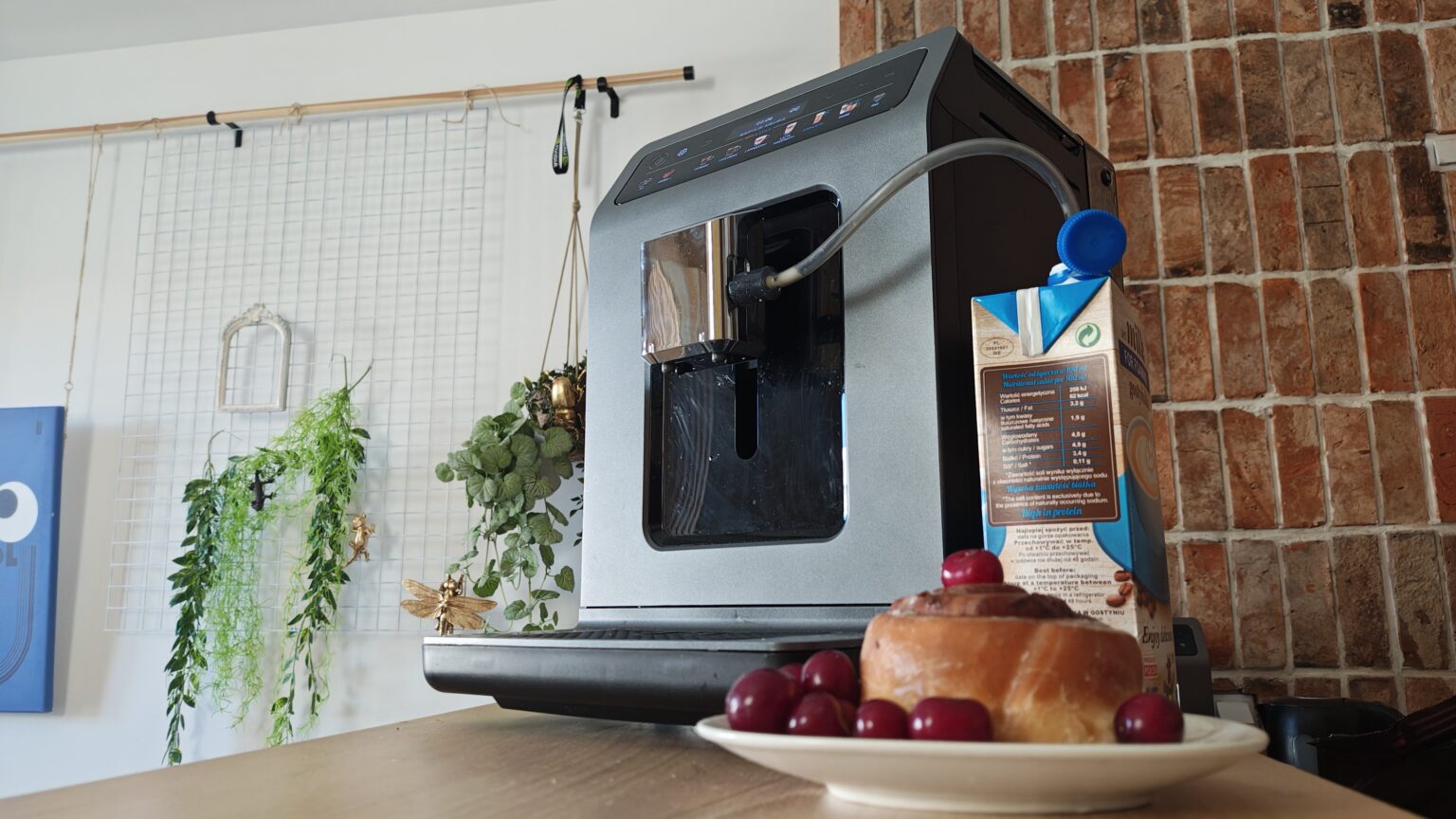 Ten ekspres robi świetne domowe Cold Brew i właśnie sporo potaniał! Ekspres Krups Evidence Hot&Cold stojący obok kartonu z mlekiem i cynamonki.