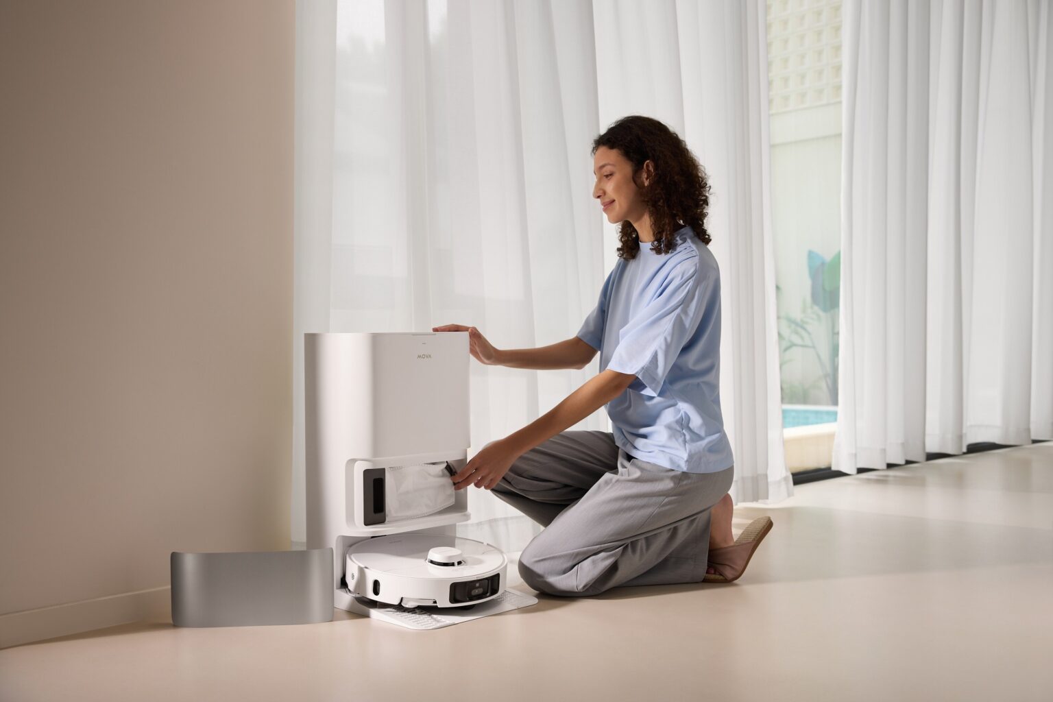 Kobieta kuca przy robocie sprzątającym MOVA P10 Pro Ultra ze stacją dokującą.