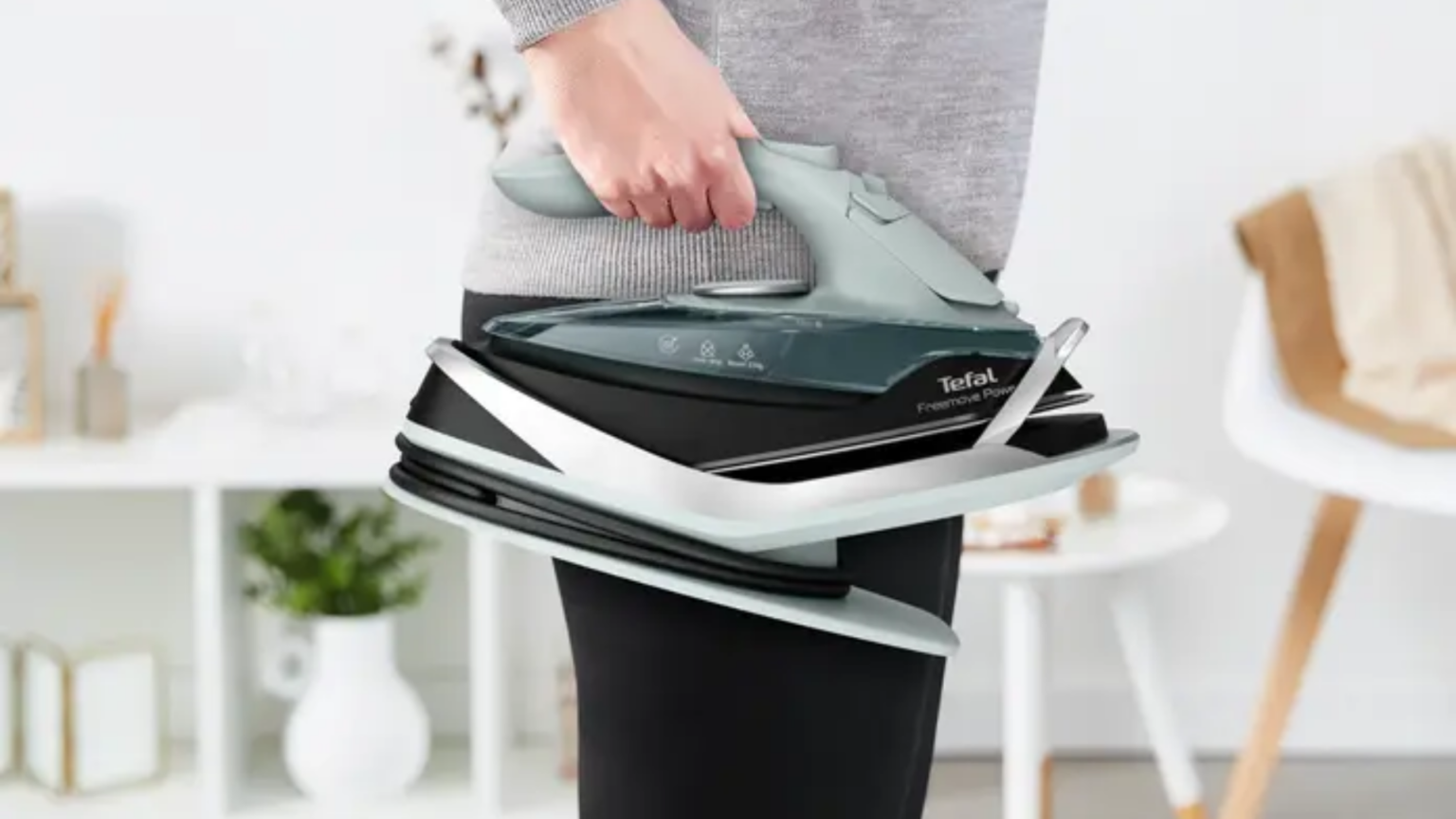 Mężczyzna trzyma żelazko TEFAL FV6675E0.