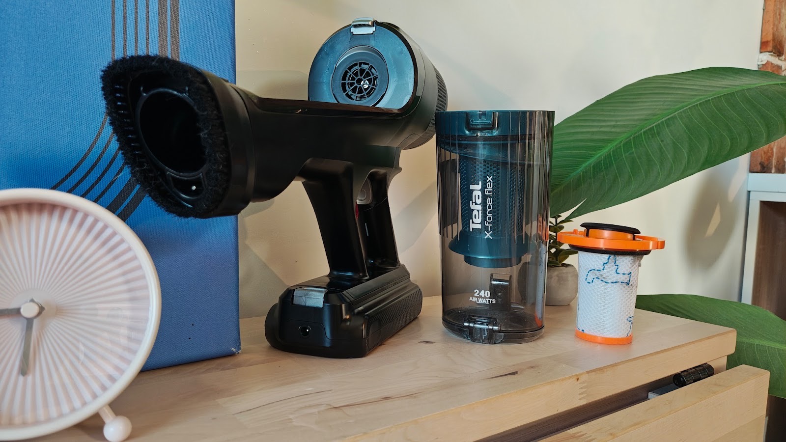 Odkurzacz bezprzewodowy Tefal X-Force Flex 14.80, zbiornik na brud i filtr HEPA na stoliku.