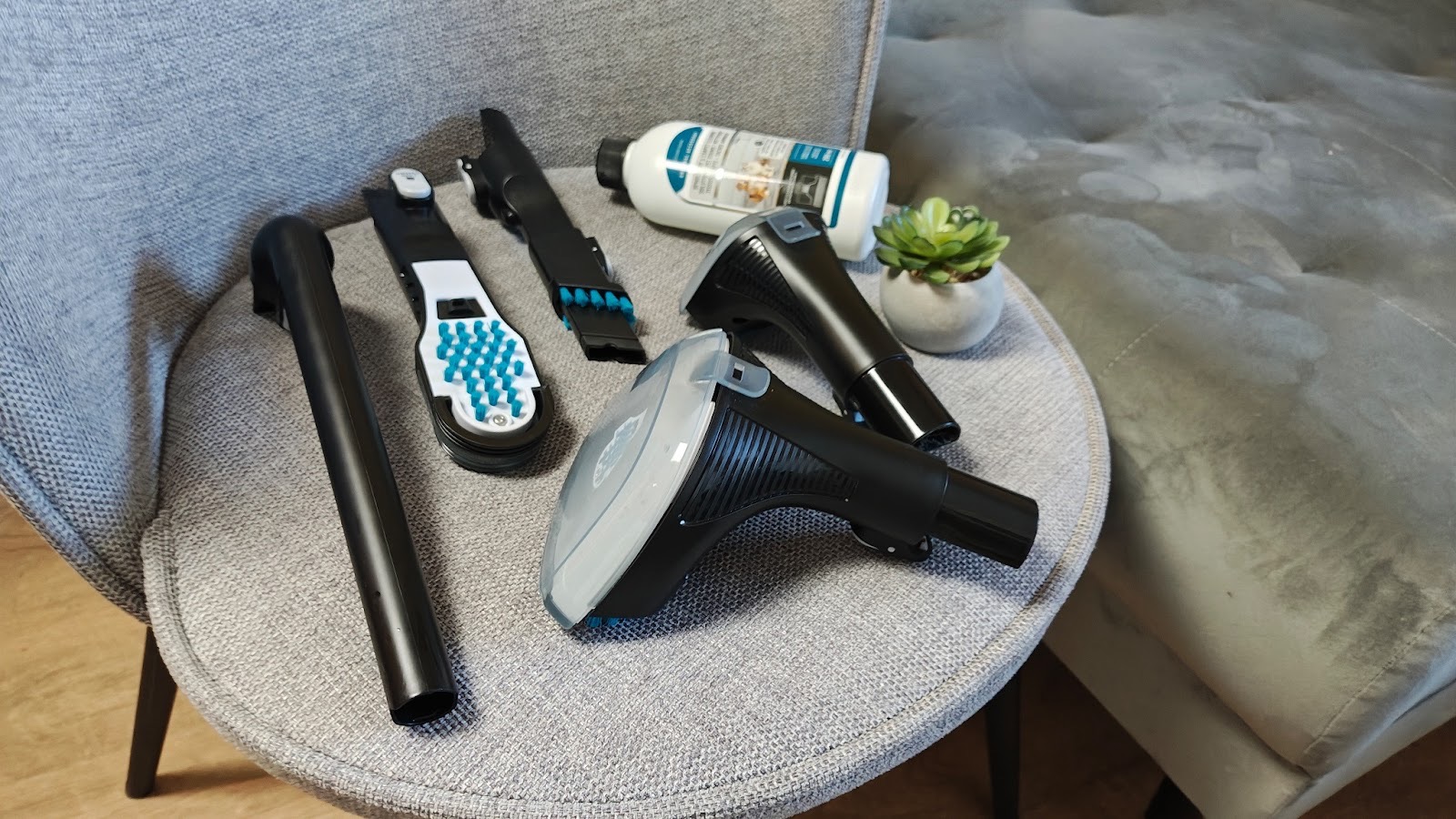 Wszystkie końcówki odkurzacza piorącego Tefal Clean It na fotelu.